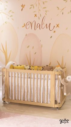 a baby's room with a crib and wall decal that says name