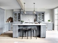 two stools sit at the center of a kitchen island