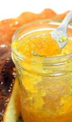 a spoon in a jar filled with orange marmalade