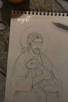 a drawing of jesus holding a lamb on top of a table next to a candle