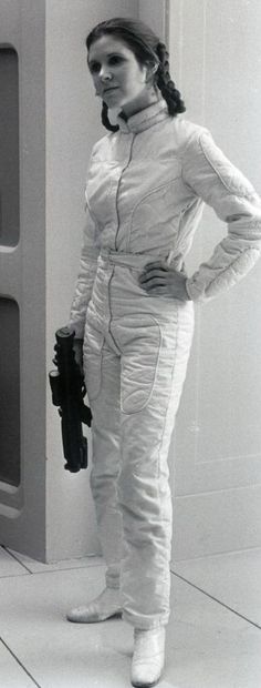 a woman in a space suit standing next to an oven with her hands on her hips