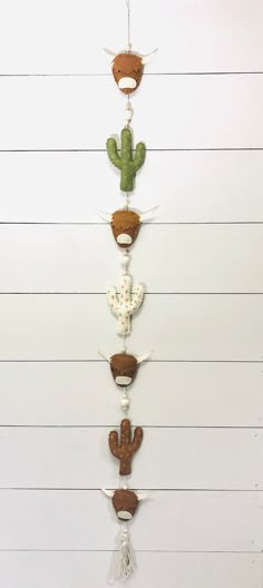 a wall hanging made out of different types of animal heads and cactuses on it's sides