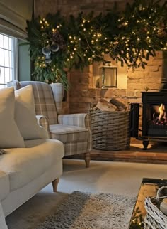 a living room filled with furniture and a fire place next to a window covered in christmas wreaths