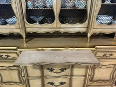 an antique china cabinet with glass doors and drawers