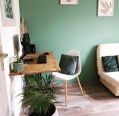 a living room with green walls and white furniture