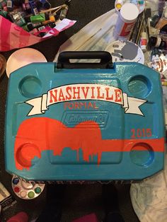 a blue and red lunch box sitting on top of a table next to other items