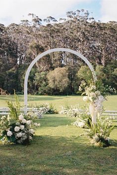 an outdoor ceremony setup with white flowers and greenery