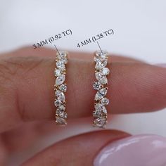 a woman's finger with two rows of diamond earrings on top of her fingers