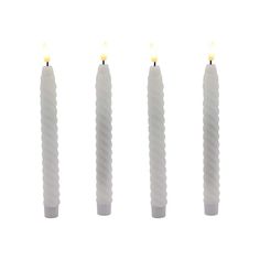 three white candles are lined up in a row