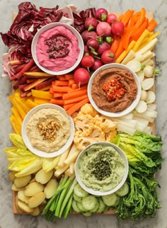 a platter filled with different types of vegetables and dips