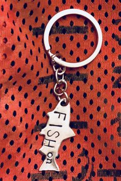 a metal keychain with the word fish on it