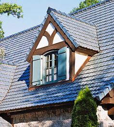 a house that has some windows in the front and side of it with blue shutters