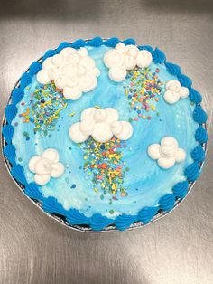 a blue cake with white frosting and sprinkles