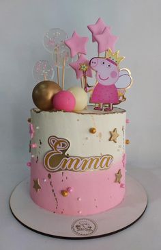 a pink and gold cake with peppa pig on top