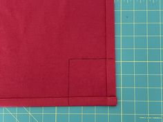 a red piece of cloth sitting on top of a cutting board