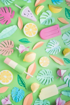 colorful paper cutouts on a green surface with flowers and leaves in the middle, including lemons