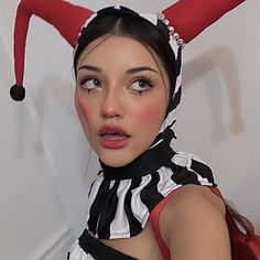 a woman dressed in a costume with horns on her head and wearing a black and white striped dress