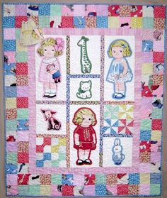 a quilted wall hanging with children's pictures on it