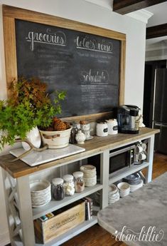 a chalkboard is on the wall behind a shelf with coffee cups and mugs