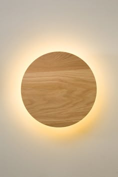 a round light fixture mounted to the side of a wall with a wooden plate on it