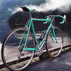 a blue bicycle parked on the side of a lake