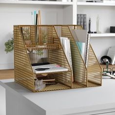 a desk with some books and other items on it in a room that has white walls