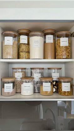 the shelves are filled with different types of food and containers on them, all labeled with labels