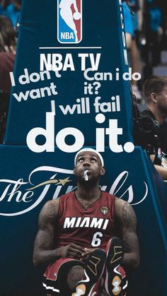 a man sitting on top of a blue bench next to a sign that says do it