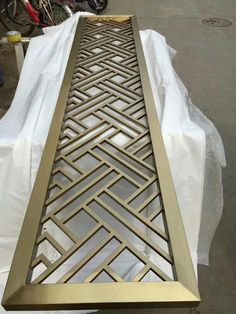 a table that has some kind of metal design on it's side and is covered in plastic