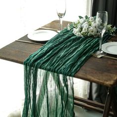 the table is set with white flowers and greenery, along with two wine glasses