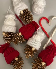 knitted pine cones and christmas decorations are arranged on a white surface with candy canes in the foreground