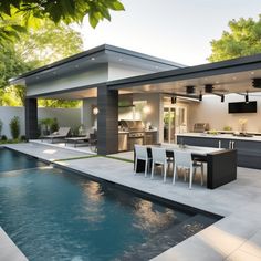 an outdoor kitchen and dining area next to a swimming pool