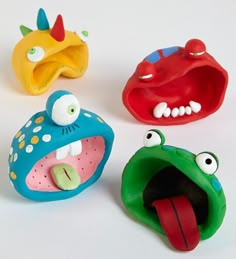 three plastic toys that look like monsters with mouths and eyes, one in the shape of a mouth