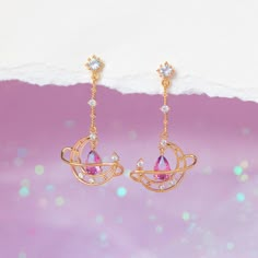 Lose yourself in the light and mystery of the skies above! Our Lost In Orbit Dangle Earrings are a wonderful spin on the classic celestial motif. These earrings feature a delicate pear shaped gradient stone that is absolutely mesmerizing. 18k gold plated, 18k rose gold plated, or rhodium plated over brass with a protec Fantasy Accessories Earrings, Celestial Teardrop Earrings Gift, Celestial Teardrop Earrings For Gift, Artistic Earrings, Moon Studs, Necklace Chain Lengths, Pretty Jewelry, Fantasy Jewelry, Copper Earrings