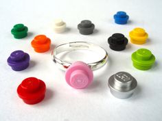 there are many different colored buttons on the table next to each other, including a ring