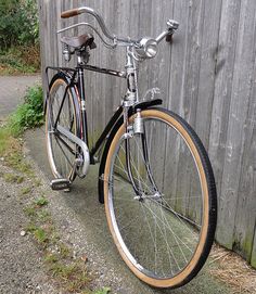 a bicycle parked next to a wooden fence