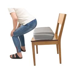 a woman kneeling down next to a chair with a cushion on it's seat