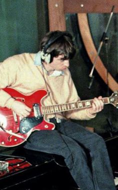 a man with headphones playing an electric guitar