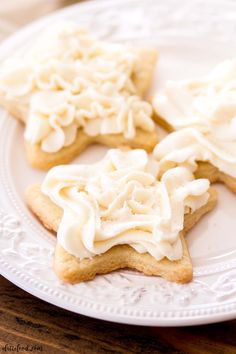 three cookies with white frosting on a plate