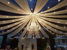 the ceiling is decorated with white drapes and lights