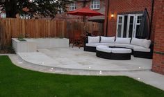 an outdoor living area with grass, couches and umbrellas in the back yard