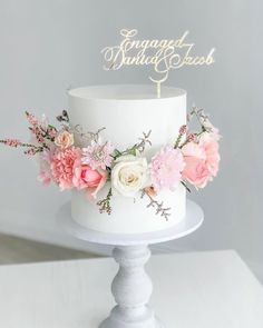 a white cake topped with pink and white flowers