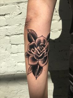 a black and white rose tattoo on the arm