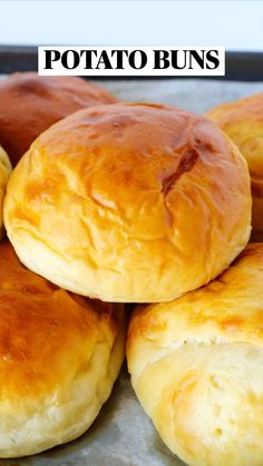 some bread rolls are stacked on top of each other with the words potato buns above them