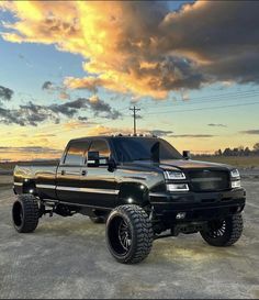 a large black truck parked on top of a parking lot