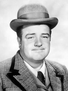 a black and white photo of a man in a suit with a hat on his head