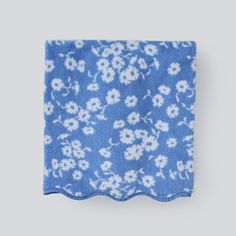 a blue and white flowered towel on a gray background