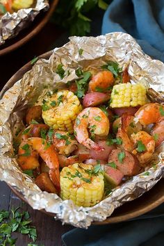 shrimp and corn on the cob in foil with parsley garnishes