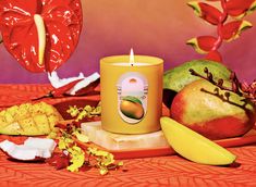 a candle is surrounded by fruit on a table