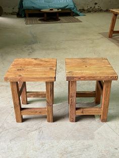 two wooden stools sitting next to each other in a room with concrete flooring